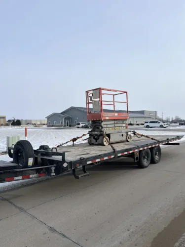 Scissor lift on our 24ft deck over tilt trailer