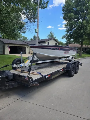 20ft flatbed trailer with winch hauling boat and boat trailer