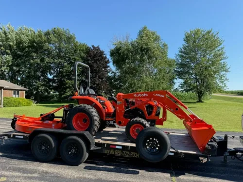 Our 20ft flatbed trailer hauling a Kubota tractor