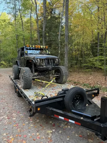 Off-road Jeep on 24ft deckover tilt trailer